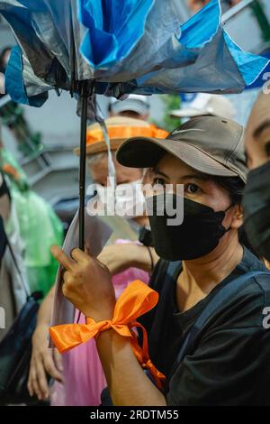 Bangkok, Thailand. 23. Juli 2023. Eine Unterstützerin von Pita Limjaroenrat trägt ein orangefarbenes Band, um ihre Unterstützung bei einer Demonstration an der Kreuzung von Asoke zu zeigen. Der politische Aktivist Sombat Boonngamanong, auch bekannt als ‚Bor Kor Lai Jud‘, organisierte eine Demonstration gegen den Senat, weil er Pita Limjaroenrats Versuch, Ministerpräsident zu werden, nicht unterstützte. Kredit: SOPA Images Limited/Alamy Live News Stockfoto