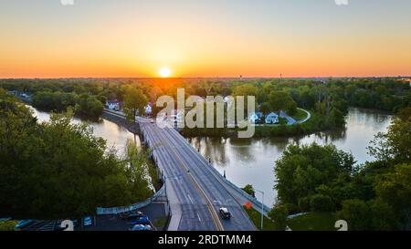 hufeisenförmige kleine Stadt am riverbend mit Brücke über Wasser bei Sonnenaufgang und Sonnenuntergang Stockfoto