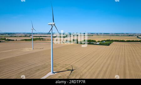 Zwei Windturbinen auf dem Feld mit Turbinen am Horizont Stockfoto