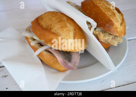 Fischbrotchen oder Fisch-Sandwich mit Matjes Hering und Zwiebeln und Brathering Stockfoto