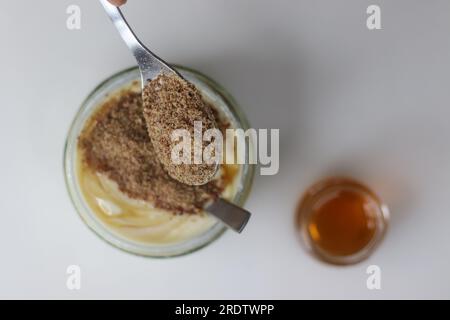 Mischung aus Quark, Honig und Leinsamen. Ein gesundes Dessert zum Konsum nach dem Mittagessen. Es kann helfen, das Immunsystem zu verbessern, da sie Nährstoffe und Verbindungen enthalten Stockfoto