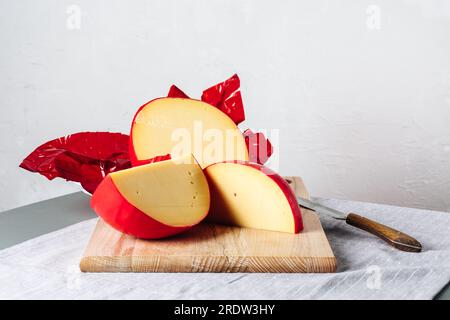 In Scheiben geschnittener Edamskäse, mit roter Wachsschicht bedeckt. Stockfoto