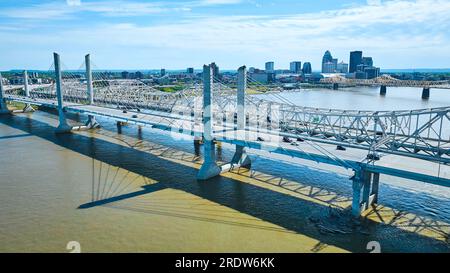 Weiße Hängebrücke über dem dunkelbraunen Flussufer Ohio River mit unvergleichlichem Hintergrund Stockfoto