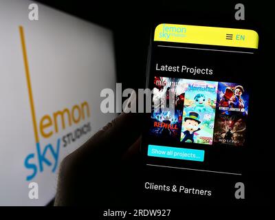 Person, die ein Handy mit der Website des malaysischen Videospielunternehmens Lemon Sky Studios auf dem Bildschirm hält, mit Logo. Konzentrieren Sie sich auf die Mitte des Telefondisplays. Stockfoto