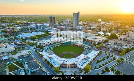 Der goldene Sonnenaufgang glüht über der Innenstadt von Fort Wayne und dem Parkview Field Stadium Aerial Stockfoto