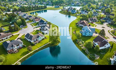 Geteilte Nachbarschaft mit großem gewundenen Teich mit Springbrunnen und Sackgasse mit zusätzlichen Bauten Stockfoto