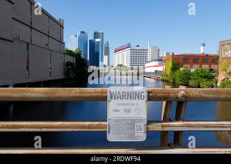 Ein Blick auf Dutch Kills--ein Abschnitt des Newtown Creek, New York City--mit Beschilderung vor dem Verzehr von Fischen und Muscheln aus der Gezeitenmündung. Stockfoto