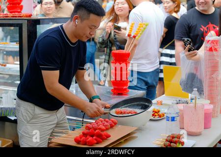 Besitzer des Chan Bai Mei Süßwarenladens, der kandierte Erdbeeren auf einem Stock herstellt, 冰糖葫蘆, ähnlich Tanghulu, in Dragon Fes, 24. Juni 2023, New York. Stockfoto