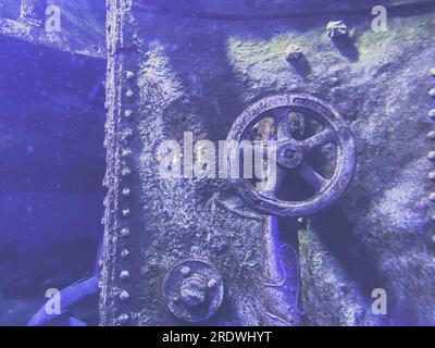 Gesunkenes U-Boot. Der Wasserhahn und der Deckel waren von Rost und Moos bedeckt, die lange Zeit mit Wasser in Berührung gekommen waren. Das Metall ist wegen des Wracks gesunken. Stockfoto