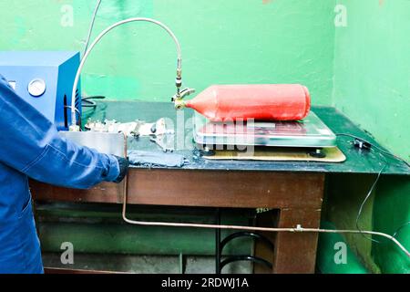 Gewerbliche Industrieanlagen, Station zum Befüllen von Feuerlöschern mit Manometern und Schläuchen in der Werkstatt im Werk. Stockfoto