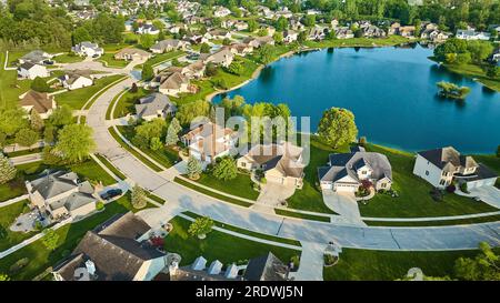 Anlage mit Blick auf den Teich und Seeblick mit einsamer Insel mit drei Bäumen in der Nachbarschaft mit großen Häusern aus der Vogelperspektive Stockfoto