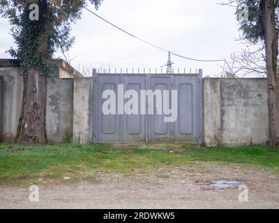 Verriegeltes graues Tor. Privates Territorium. Für Eintritt geschlossen. Zaun mit Tor. Es gibt keinen Durchgang Stockfoto