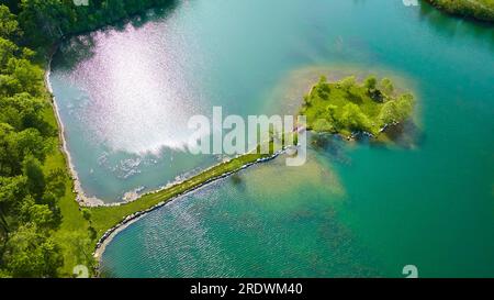 Blick auf die kleine Insel mit Landbrücke und roter Wanderbrücke, umgeben von türkisfarbenem Wasser Stockfoto