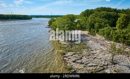 Blauer Himmel mit Fluss, der um die Kalksteinküste fließt, mit grünen Sommerbäumen aus der Vogelperspektive Stockfoto