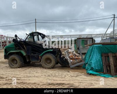 Ein Frontlader auf einer Baustelle entfernt Fremdkörper aus Stahlbeton. Sammlung und Entfernung von freistehenden Baustoffen. Stockfoto