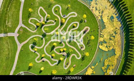 Die Drohne wurde über einen Teich um den Ariel Foundation Park und seinen Baumweg geschossen Stockfoto