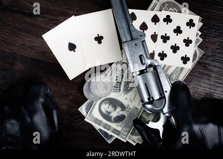 Die Hand eines Toten. Zweipaarige Pokerhand bestehend aus schwarzen Assen und schwarzen Achten und Spielerhand mit Revolverpistole. Stockfoto