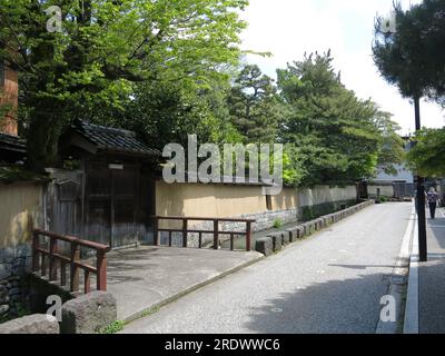 Der Nagamachi Samurai-Bezirk in Kanazawa zeichnet sich durch Wasserkanäle entlang der verwinkelten Straßen, gelben Erdmauern und historischen Residenzen aus. Stockfoto