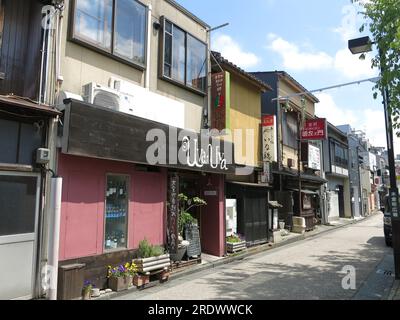Blick auf eine Straße in der Stadt Kanazawa, Kiguramachi Straße, die Gebäude im japanischen Stil einschließlich des italienischen Restaurants „Uva Uva“ zeigt. Stockfoto