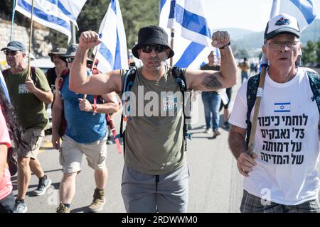 Jerusalem, Israel. 22. Juli 2023. Während der Demonstration marschiert ein Demonstrant nach Jerusalem und erhebt die Hände. Zehntausende Demonstranten gegen die Reform schwenken die israelische Flagge, während sie die Zufahrtsstraße nach Jerusalem erklimmen, die einen 4-Tage-marsch beendet, der in Tel Aviv begann, um gegen die derzeit laufenden Gesetzesüberarbeitungen zu demonstrieren. (Credit Image: © Matan Golan/SOPA Images via ZUMA Press Wire) NUR ZUR REDAKTIONELLEN VERWENDUNG! Nicht für den kommerziellen GEBRAUCH! Stockfoto