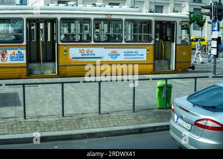 Budapest, HU – 11. Juni 2023 Landschaftsansicht einer Straßenbahnhaltestelle mit geöffneten Türen von der Straßenbahnlinie 47 in Budapest. Stockfoto