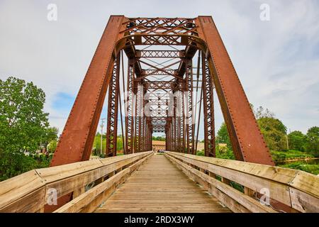 Blick auf das Gebäude durch die umgebaute Eisenbahnbrücke, die jetzt eine hölzerne Wanderbrücke in Mount Vernon ist Stockfoto