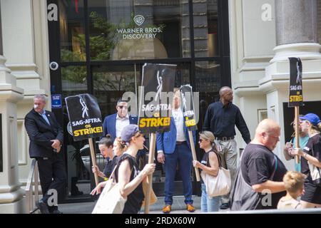 New York City: Der Streik geht weiter unter der Schriftstellergilde von Amerika und den Mitgliedern der SAG-AFTRA Union, wobei Streikposten an mehreren Standorten in Manhattan die Unterhaltungsindustrie lahmlegen. Gewerkschaftsmitglieder streiken vor dem Warner Brothers Gebäude in Manhattan. Stockfoto