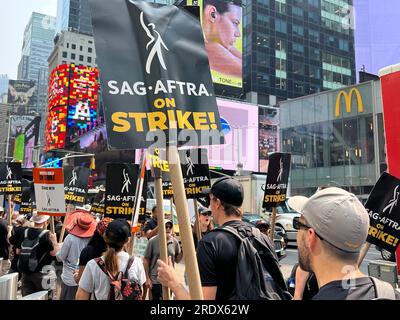 New York City: Der Streik geht weiter unter der Schriftstellergilde von Amerika zusammen mit Mitgliedern der SAG-AFTRA Union mit Streikposten an mehreren Orten in Manhattan. Gewerkschaftsmitglieder demonstrieren durch Paramount Gebäude entlang des Broadway am Times Square, was die Unterhaltungsindustrie lähmt. Stockfoto