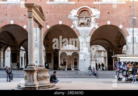 Brunnen aus dem 16. Jahrhundert an der Piazza dei Mercanti mit Touristen und einem Stand mit Souvenirs, Mailänder Stadtzentrum, Lombardei, Italien Stockfoto