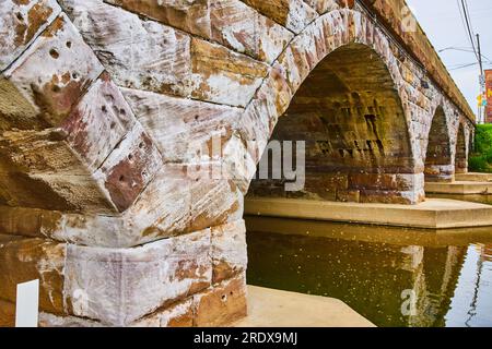 Brückenbogenboden mit Fluss- und Steinsteinen, die mit weißem und sickerndem Eisen bestrichen sind Stockfoto