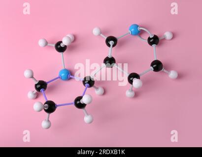 Nikotinmolekül auf pinkfarbenem Hintergrund, Draufsicht. Chemisches Modell Stockfoto