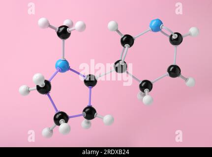 Nikotinmolekül auf pinkfarbenem Hintergrund. Chemisches Modell Stockfoto