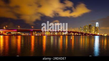 Panoramafoto von Miami bei Nacht. Bayside Marketplace Miami Downtown hinter MacArthur Causeway vom Venetian Causeway. Stockfoto