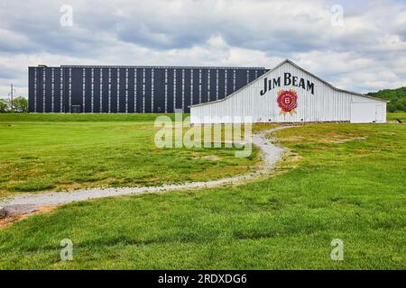 Bourbon Rackhouse Lagerhaus für Jim Beam unter bewölktem Himmel und mit grünem Gras und einem Pfad Stockfoto