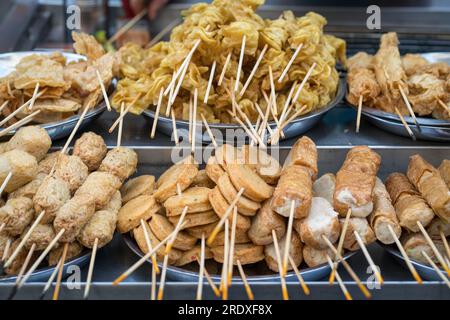 Asiatisches Street Food, Lok Lok, Fleisch- und Fischkuchen auf Spießen. Stockfoto