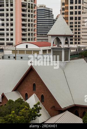 Bangkok, Thailand - 16. Juli 2023 - die christliche Kirche ist umgeben von modernen architektonischen Außengebäuden. Selektiver Fokus. Stockfoto