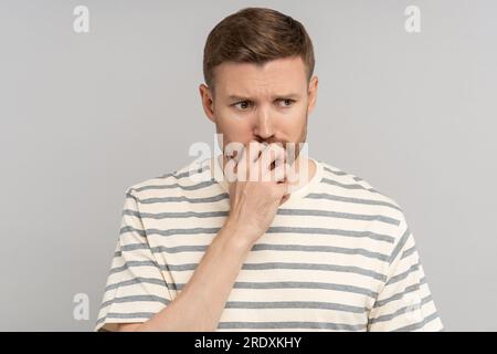 Gestresster, aufmerksamer Mann, der an eine Problemlösung denkt, müde mit einem unglücklichen Gesichtsausdruck Stockfoto