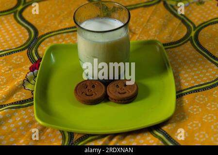 Frühstücksmenü mit einem Glas Milch und zwei Keksen Stockfoto