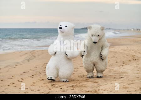 Animateure, die als Eisbären verkleidet sind, unterhalten die Leute am Strand Stockfoto