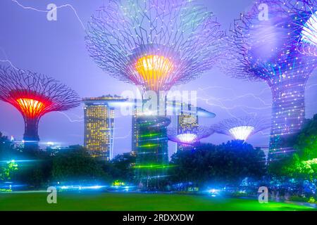 Die abendliche Lichtshow im Supertree Grove of the Gardens an der Bucht in Singapur. Das Marina Bay Sands Hotel ist im Hintergrund zu sehen. Stockfoto