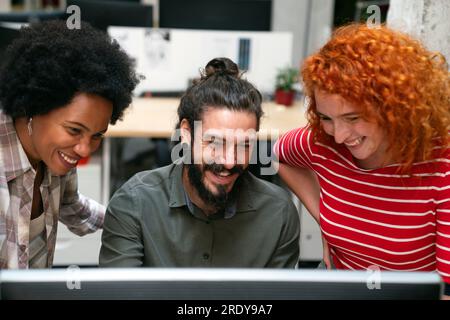 Lächelnd treffen sich verschiedene Kollegen in einem Brainstorming in der Vorstandsetage, um gemeinsam Finanzstatistiken zu diskutieren Stockfoto
