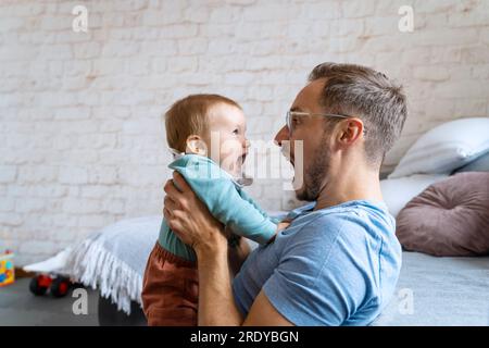 Verspielter Vater, der zu Hause mit dem kleinen Jungen schrie Stockfoto