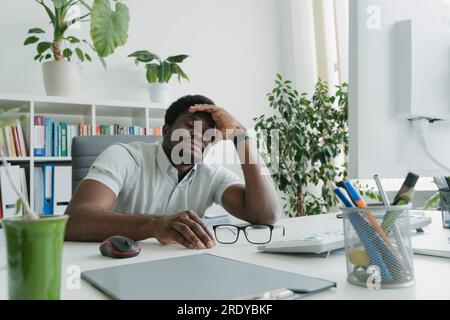 Junger Geschäftsmann, der im Büro am Schreibtisch schläft Stockfoto