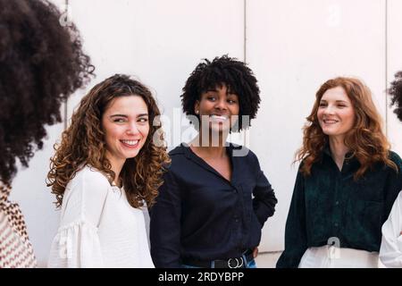 Lächelnde junge Geschäftsfrauen, die zusammen Zeit verbringen Stockfoto