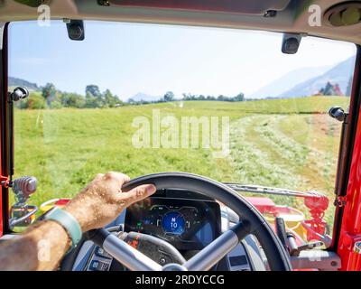 Hand des Landwirts, die das Lenkrad des Traktors im Betrieb hält Stockfoto