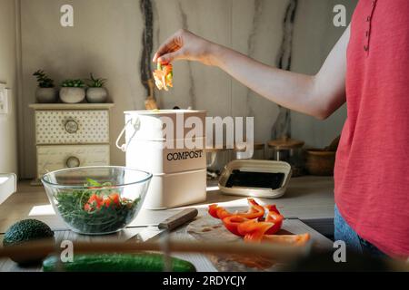 Eine Frau, die zu Hause Müll in den Kompost wirft Stockfoto