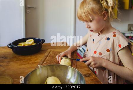 Ein Mädchen schneidet Äpfel in der Küche zu Hause Stockfoto