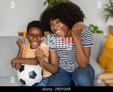 Glückliche Mutter und Sohn, die zuhause auf dem Sofa saßen Stockfoto