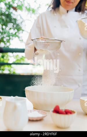 Der Koch siebt Mehl durch das Siever Stockfoto