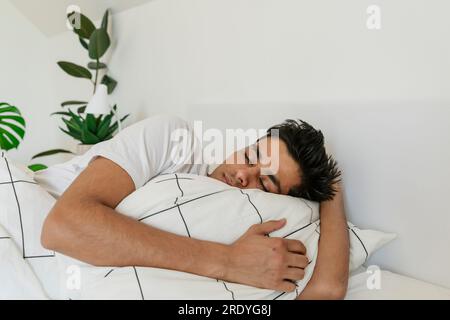 Junger Mann schläft zu Hause im Bett Stockfoto